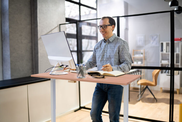 mann-steht-beim-arbeiten-am-elektrisch-höhenverstellbarem-schreibtisch